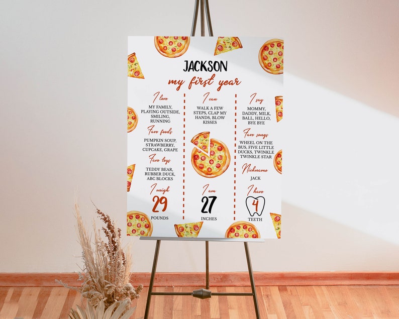 May include: A white printable poster with a pizza theme for a first birthday. The poster has a red and white striped border and features a watercolor illustration of a pizza with the text "JACKSON my first year". The poster includes details about the child's first year, such as their weight, height, and favorite foods.