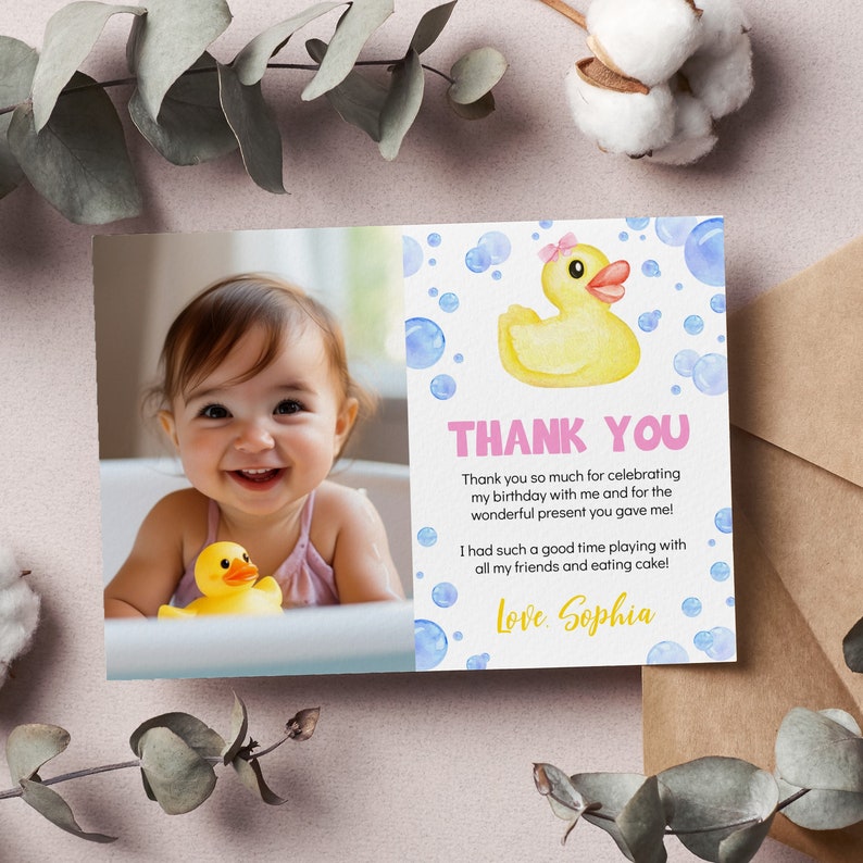 May include: A rectangular thank you card featuring a photograph of a smiling child with a yellow rubber duck on the left side. The right side displays a watercolor yellow rubber duck with a pink bow, blue bubbles, and the text Thank You, Love, Sophia.