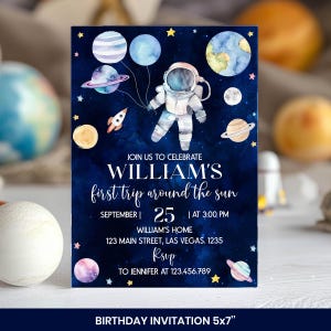 Pu&ograve; includere: Un biglietto d'invito di compleanno rettangolare con uno sfondo spaziale blu scuro, pianeti ad acquerello, stelle e un astronauta che tiene dei palloncini. Il testo recita: JOIN US TO CELEBRATE WILLIAM'S first trip around the sun.