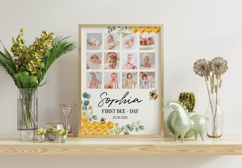 May include: A framed photo collage print featuring twelve square images of a baby arranged in a grid, with the name Sophia, the text FIRST BEE-DAY, and the date 22.09.202X. The design includes watercolor illustrations of honeycombs, bees, and flowers.