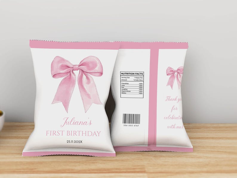 May include: Two white snack bags with pink trim featuring a large pink bow illustration. The front displays "Juliana's FIRST BIRTHDAY" and "25.11.202X". The back includes a "NUTRITION FACTS" label, a barcode, and the text "Thank you for celebrating with me".