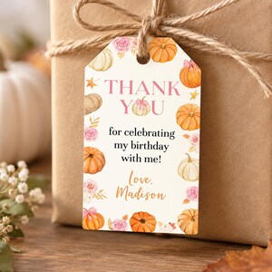 May include: A rectangular gift tag with a white background featuring watercolor illustrations of orange and white pumpkins and pink roses. The text reads: THANK YOU for celebrating my birthday with me! Love, Madison. The tag is tied with brown twine.