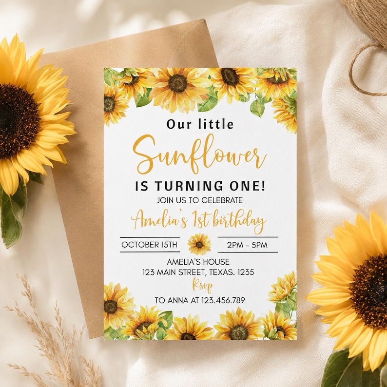 May include: A rectangular birthday invitation card featuring a sunflower border with the text: Our little Sunflower IS TURNING ONE! JOIN US TO CELEBRATE Amelia's 1st birthday OCTOBER 15TH 2PM - 5PM AMELIA'S HOUSE 123 MAIN STREET, TEXAS. 1235 RSVP TO ANNA AT 123.456.789