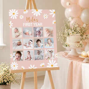 May include: A rectangular pink sign featuring white daisy illustrations and the text "Mila's FIRST YEAR" in white and brown. The sign displays a grid of twelve individual photographs of a baby at different stages of development.