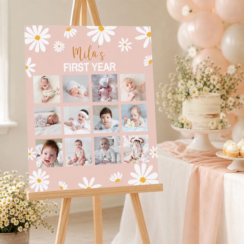 May include: A rectangular pink sign featuring white daisy illustrations and the text "Mila's FIRST YEAR" in white and brown. The sign displays a grid of twelve individual photographs of a baby at different stages of development.