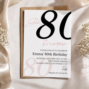 May include: A white rectangular birthday invitation card with large black numbers 80, pink script text reading Shhh... it's a surprise!, and black printed details for Emma's 80th birthday on Saturday, October 12th at 5PM at 123 Main Street, Los Angeles, CA.