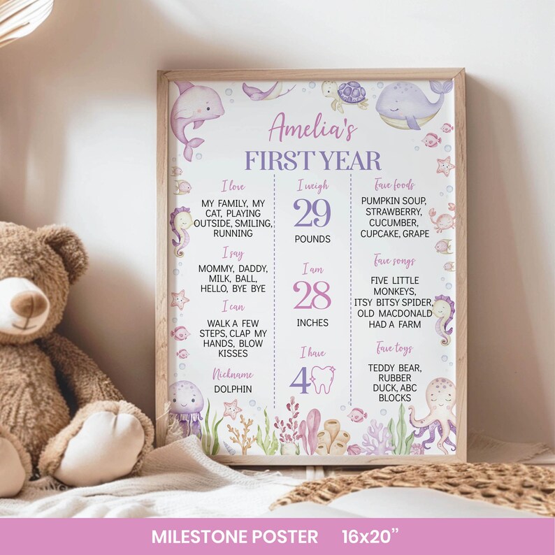 May include: A rectangular milestone poster titled Amelia's FIRST YEAR with purple text and watercolor sea creature illustrations including a dolphin, whale, and octopus. It lists personal details like 29 pounds and 28 inches in a grid format.
