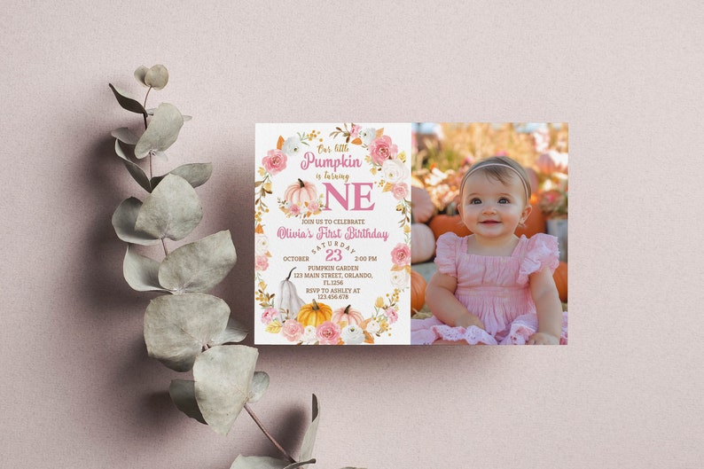 Pu&ograve; includere: Un invito rosa e oro con un design a forma di zucca e ghirlanda di fiori. Il testo recita "One little pumpkin is turning one" e "Olivia's First Birthday". L'invito include la data, l'ora e il luogo della festa.