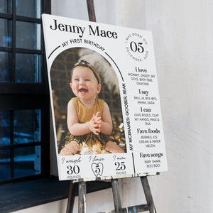 Puede incluir: Un cartel blanco con texto negro y una foto de una ni&ntilde;a peque&ntilde;a. El cartel dice "Jenny Mace, Mi Primer Cumplea&ntilde;os, Nacida El 05 De Diciembre De 202X". Tambi&eacute;n indica el peso del beb&eacute;, 30 libras, y la altura, 25 pulgadas. El cartel incluye informaci&oacute;n sobre los gustos del beb&eacute;, como sus comidas y canciones favoritas.