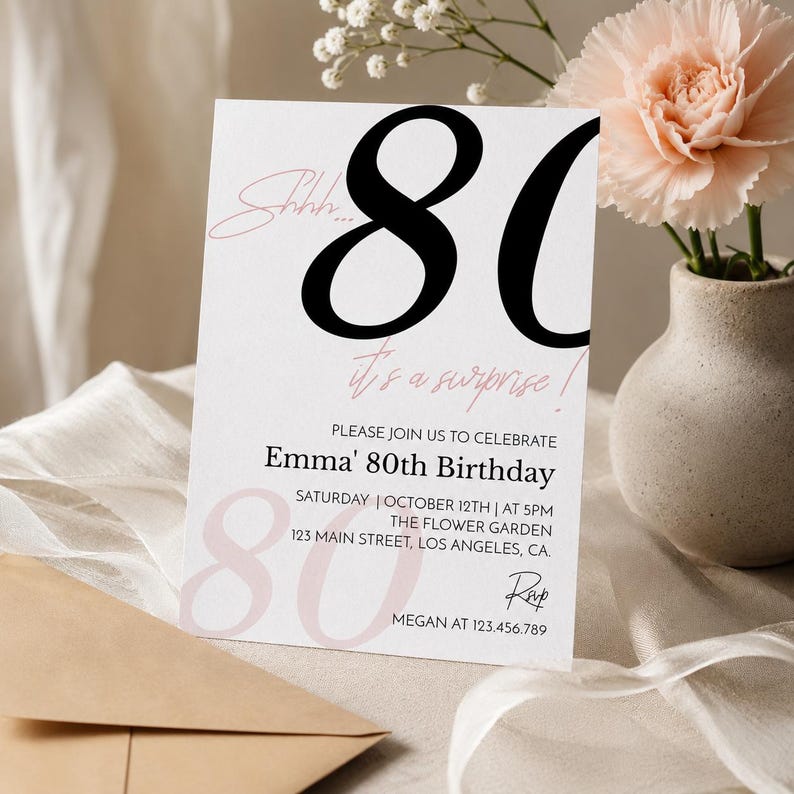May include: A white rectangular birthday invitation card featuring large black numbers 80, pink script text reading Shhh... it's a surprise!, and printed details for Emma's 80th birthday celebration on October 12th at 5PM at The Flower Garden in Los Angeles.