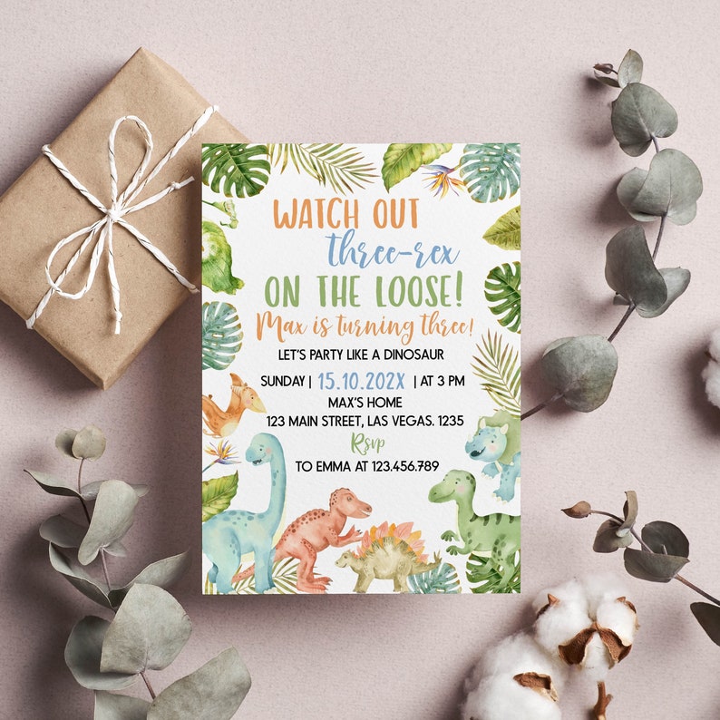 May include: A rectangular birthday invitation card featuring watercolor illustrations of various dinosaurs and tropical leaves. The text reads: WATCH OUT three-rex ON THE LOOSE! Max is turning three! LET'S PARTY LIKE A DINOSAUR SUNDAY | 15.10.202X | AT 3 PM MAX'S HOME 123 MAIN STREET, LAS VEGAS. 1235 RSVP TO EMMA AT 123.456.789