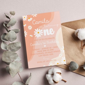 Peut inclure: Une carte d'invitation d'anniversaire rectangulaire avec un fond p&ecirc;che, des illustrations de marguerites blanches et du texte blanc indiquant Camila is turning one, join us to celebrate Camila's 1st birthday, Sunday August 10 202X from 2pm to 5pm, Daisy Garden 123 Main Street Las Vegas 1234, RSVP Emma at 123.456.789.