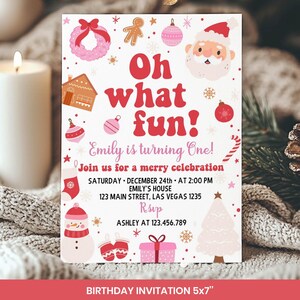 May include: A white rectangular birthday invitation card featuring the red text Oh what fun! and Emily is turning One! surrounded by Christmas illustrations including Santa, a gingerbread house, a snowman, a pink tree, and presents.