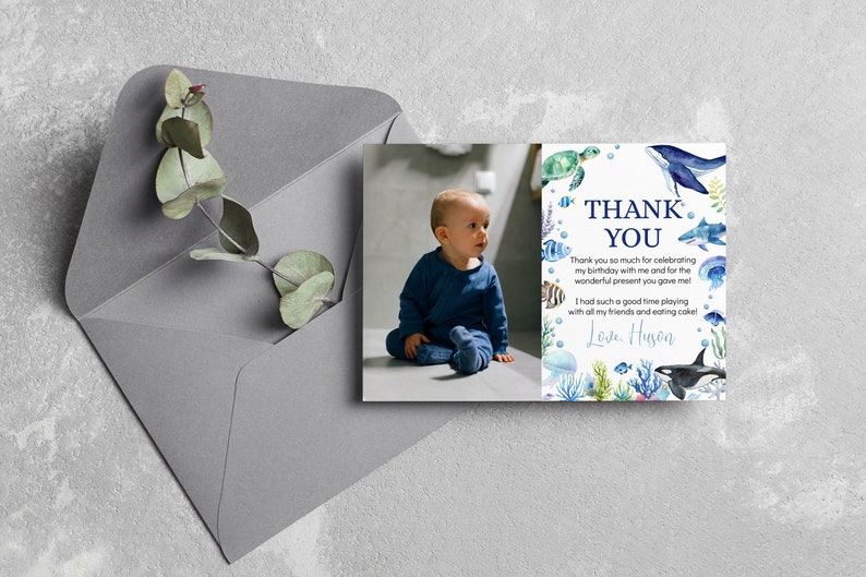 May include: A rectangular thank you card featuring a photograph of a toddler in a blue outfit on the left and watercolor illustrations of sea creatures including a whale, shark, turtle, and jellyfish on the right with the text Thank You.