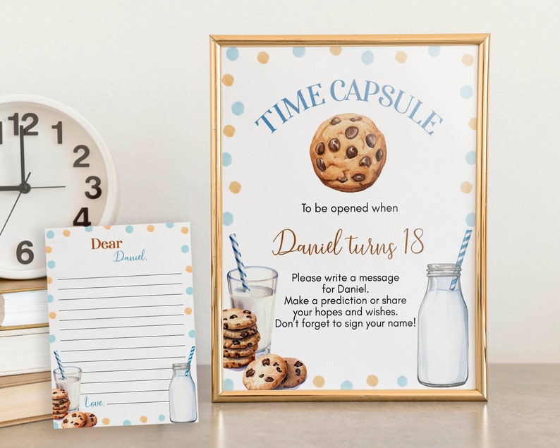 Op de afbeelding: Een gouden lijst met blauwe en gouden stippen waarop "Time Capsule" staat met een afbeelding van een chocolade chip cookie. Het bord bevat ook de tekst "To be opened when Daniel turns 18". Onder de tekst staat een bericht waarin de gebruiker wordt gevraagd om een bericht voor Daniel te schrijven, een voorspelling te doen of zijn hoop en wensen te delen. Het bord bevat ook een afbeelding van een glas melk en een melkfles.