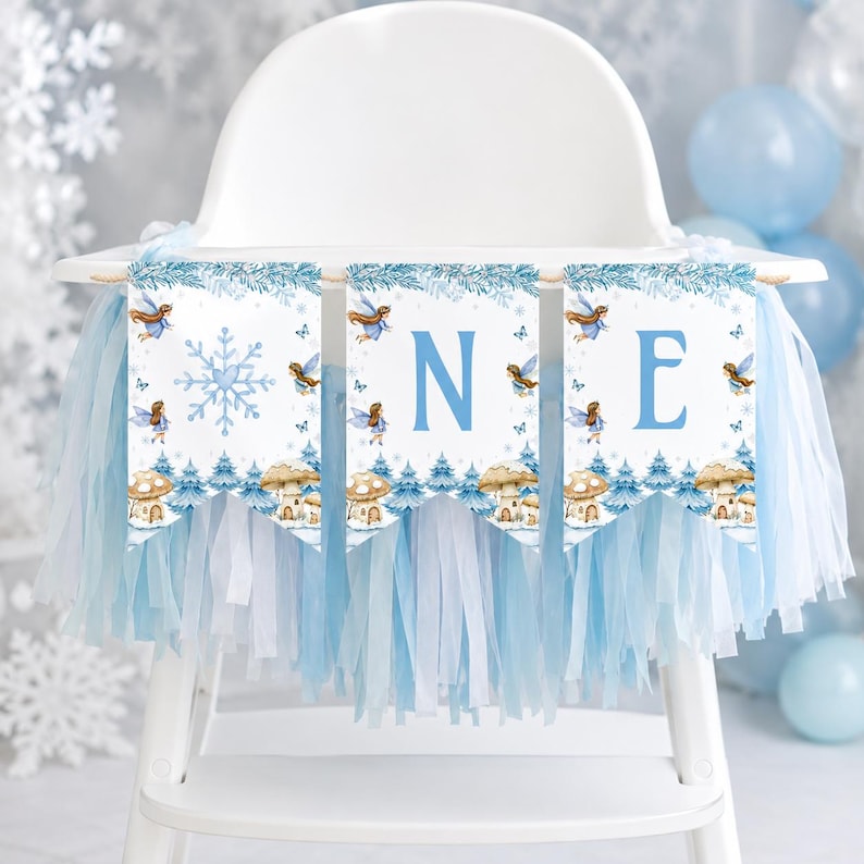 May include: A high chair banner featuring three white pennants with blue snowflake, fairy, and mushroom illustrations. The letters O, N, and E are printed in blue on each pennant. The banner is decorated with light blue and white hanging fringe.