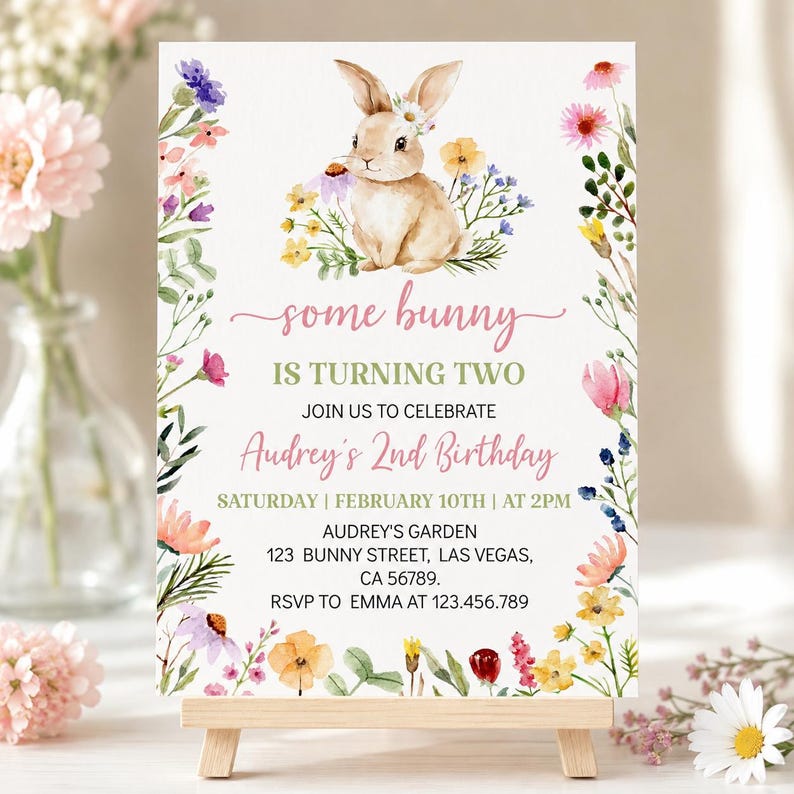 K&ouml;nnte beinhalten: Eine rechteckige Geburtstagseinladungskarte mit einer Aquarellillustration eines braunen Hasen, umgeben von bunten Wildblumen. Der Text lautet: some bunny IS TURNING TWO JOIN US TO CELEBRATE Audrey's 2nd Birthday SATURDAY | FEBRUARY 10TH | AT 2PM AUDREY'S GARDEN 123 BUNNY STREET, LAS VEGAS, CA 56789. RSVP TO EMMA AT 123.456.789.