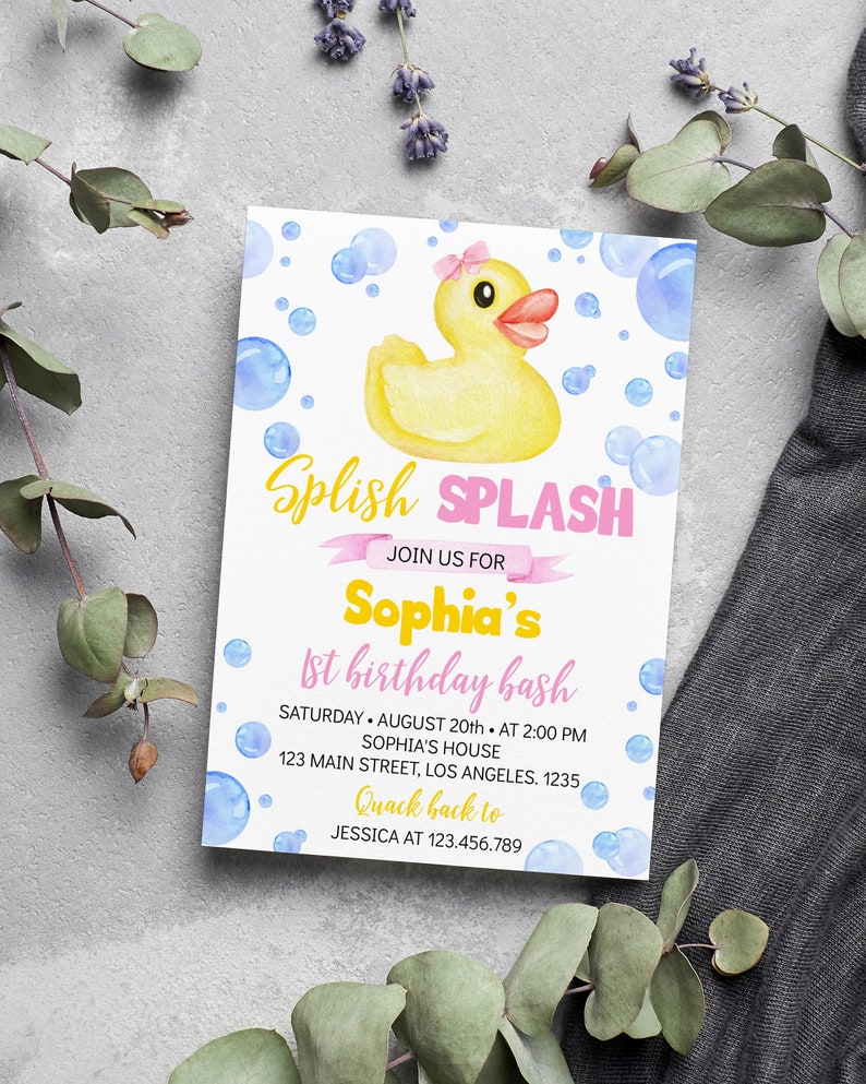 May include: A rectangular invitation card featuring a yellow rubber duck with a pink bow, surrounded by blue watercolor bubbles. The text reads: Splish SPLASH JOIN US FOR Sophia's 1st birthday bash SATURDAY AUGUST 20th AT 2:00 PM SOPHIA'S HOUSE 123 MAIN STREET, LOS ANGELES. 1235 Quack back to JESSICA AT 123.456.789.