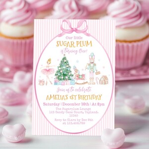 May include: A rectangular birthday invitation card with a pink and white vertical striped background. The center features a pink oval frame with a bow, containing illustrations of a ballerina, a Christmas tree, a rocking horse, and a nutcracker.