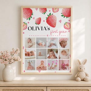 K&ouml;nnte beinhalten: Ein rechteckiges Wandposter mit wei&szlig;em Hintergrund, Aquarell-Erdbeerillustrationen und kleinen rosa Herzen. Der Text OLIVIA'S first year steht &uuml;ber einem Raster aus zw&ouml;lf einzelnen Fotos eines Babys in verschiedenen Posen.