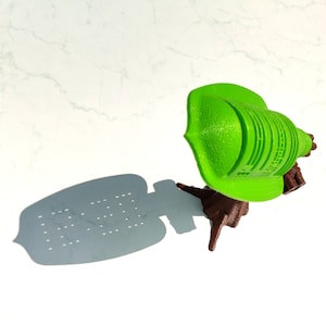 Könnte beinhalten: Ein 3D-gedrucktes Modell eines grünen Baumes mit braunem Sockel. Der Baum ist mit einem einzigartigen, geometrischen Muster gestaltet.
