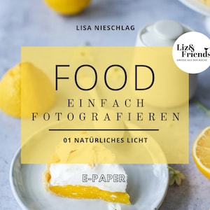 Peut inclure: Un guide de photographie culinaire jaune et blanc avec le titre "FOOD EINFACH FOTOGRAFIEREN 01 NATÜRLICHES LICHT" et le texte "Liz & Friends GRÜSSE AUS DER KÜCHE" dans un cercle noir. Le guide est sur un fond blanc avec des citrons et une part de tarte au citron meringuée.