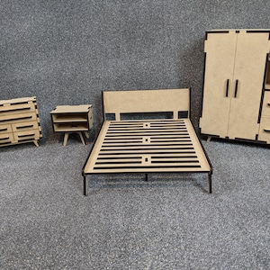 May include: A wooden bedroom set with a bed frame, two nightstands, and a wardrobe. The furniture is made of light brown wood with black trim. The bed frame has a slatted headboard and footboard.