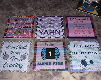 May include: Six colorful square coasters with knitting-themed sayings. The coasters feature different knitting patterns and yarn balls. The sayings include "Knitter? I prefer the term Yarn Goddess", "Behind every great knitter is a huge stash of YARN", "Kitchener stitch Set up: Front purl on Back knit on Repeat: Front knit off Front purl on Back purl off Back knit on", "Don't talk to me I'm Counting", "Feelin' 1 SUPER FINE", and "Just one more row".