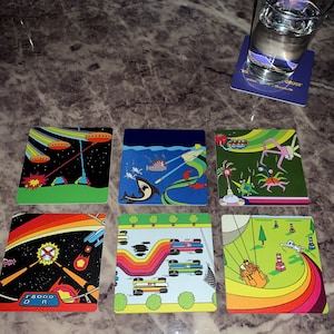 May include: Six colorful playing cards with different illustrations. The cards feature a submarine, a fish, a spaceship, a rainbow, a creature with multiple eyes, and a creature with multiple legs.
