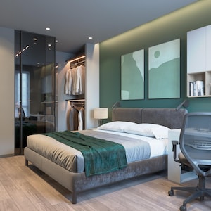 Könnte beinhalten: Ein modernes Schlafzimmer mit einem grau gepolsterten Bett, einer grünen Decke und Holzboden. Der Raum verfügt über einen Einbauschrank mit Glastüren und einen Schreibtisch mit einem grauen Bürostuhl.