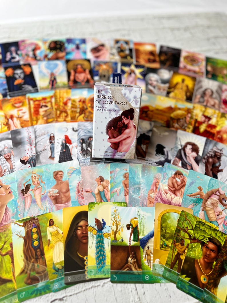 Puede incluir: Una baraja de cartas del tarot y una gu&iacute;a titulada "The Warrior of Love Tarot" con una caja que presenta una pareja abraz&aacute;ndose. Las cartas est&aacute;n ilustradas con im&aacute;genes coloridas de personas, naturaleza y s&iacute;mbolos. La baraja incluye 75 cartas.