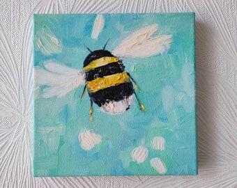 May include: A painting of a bumblebee in flight against a light blue background with white accents. The bumblebee has black and yellow stripes and white wings.