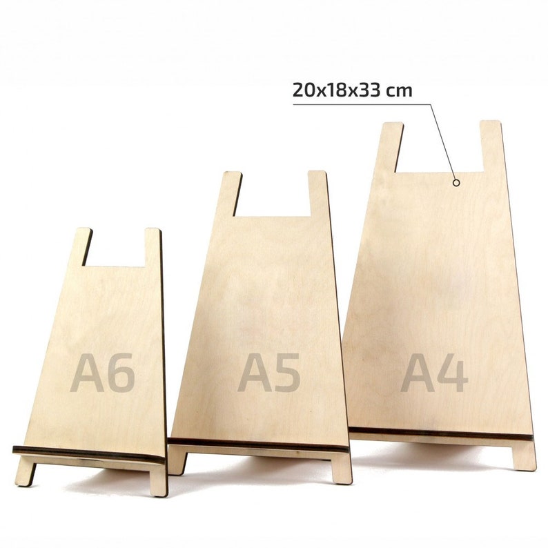 May include: Three wooden display stands in varying sizes, labelled A6, A5, and A4. The stands are made of light-coloured wood with a natural finish. The largest stand measures 33 cm high, 18 cm wide, and 20 cm deep.
