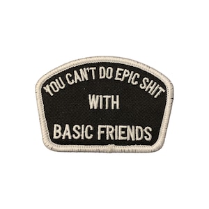 Può includere: Una toppa nera con testo bianco ricamato che recita "YOU CAN'T DO EPIC SHIT WITH BASIC FRIENDS". La toppa ha un bordo bianco e un bordo superiore curvo.