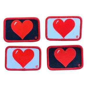 Könnte beinhalten: Vier Bügelbilder mit roten Herzen auf schwarzem und weißem Hintergrund. Die Herzen sind weiß umrandet und die Patches haben einen roten Rand.