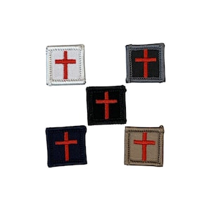 以下が含まれることがあります： 赤い十字のデザインが施された、正方形のパッチが5つ。パッチの色は白、黒、ネイビーブルー、グレー、タンなど様々です。十字はパッチの中央に配置されています。