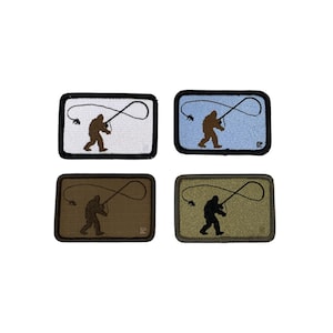 Könnte beinhalten: Vier rechteckige Aufnäher mit schwarzem Rand, die jeweils eine Silhouette von Bigfoot beim Fliegenfischen zeigen. Die Hintergründe sind weiß, hellblau, braun und olivgrün. Die Bigfoot-Figur ist braun oder schwarz.