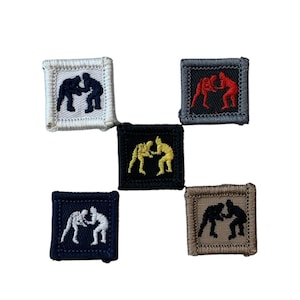 May include: Five embroidered patches featuring wrestling figures in action. The patches are square with a stitched border. The figures are in black, white, red, and yellow. The patch backgrounds are white, gray, black, navy blue, and tan.