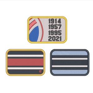 Può includere: Tre toppe rettangolari ricamate. La toppa in alto presenta un design circolare parziale rosso e blu con gli anni 1914, 1957, 1995 e 2021 in nero. La toppa in basso a sinistra ha strisce orizzontali rosse, bianche e blu scuro con un bordo dorato. La toppa in basso a destra ha strisce orizzontali azzurre, bianche e blu scuro con un bordo nero.