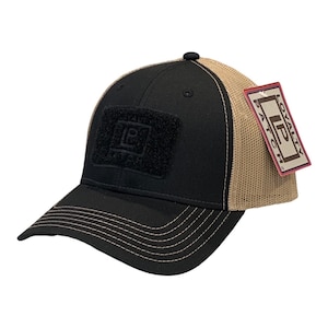 May include: Black and tan mesh trucker hat with a black velcro patch that says "Loyalty Patch" in white lettering. The hat has a brown tag that says "Loyalty Patch" in white lettering.