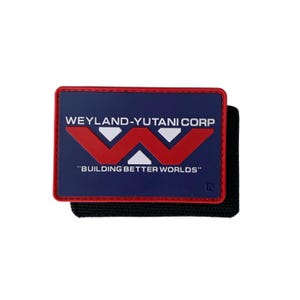 May include: A rectangular patch with a dark blue background and a red border. It features the white text WEYLAND-YUTANI CORP, a large red W logo with white accents, and the white text BUILDING BETTER WORLDS. The patch is attached to a black backing.