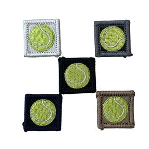 May include: Embroidered patches featuring a tennis ball design. Each patch has a square border in various colors: white, gray, black, navy blue, and brown. The tennis balls are light green with white stitching.