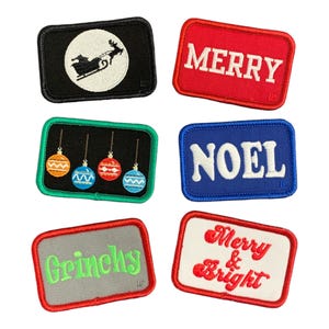 May include: Six embroidered iron-on patches with Christmas themes. The patches are rectangular and feature various colours and designs, including a reindeer pulling a sleigh, baubles, and the words "Merry", "Noel", "Grinchy", and "Merry & Bright".