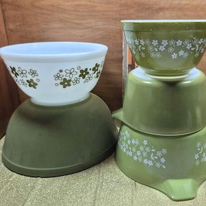 May include: A white ceramic mug with a black handle and the text "But First, Coffee" in a black, bold font. The mug is sitting on a white surface. The mug is approximately 4 inches tall.