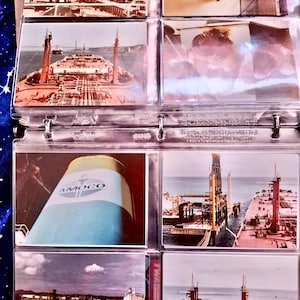 Puede incluir: Una colección de fotografías antiguas que muestran varias vistas de grandes petroleros. Las imágenes muestran los barcos en el mar, atracados en puertos y primeros planos de detalles de los barcos, incluido el logotipo "AMOCO". Las fotos se muestran en un álbum de fotos de plástico transparente.