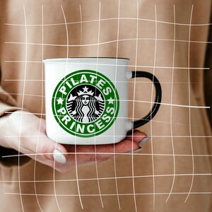 May include: White ceramic mug with a black handle. The mug has a green and white logo with the text "Pilates Princess" and a stylized image of a mermaid.