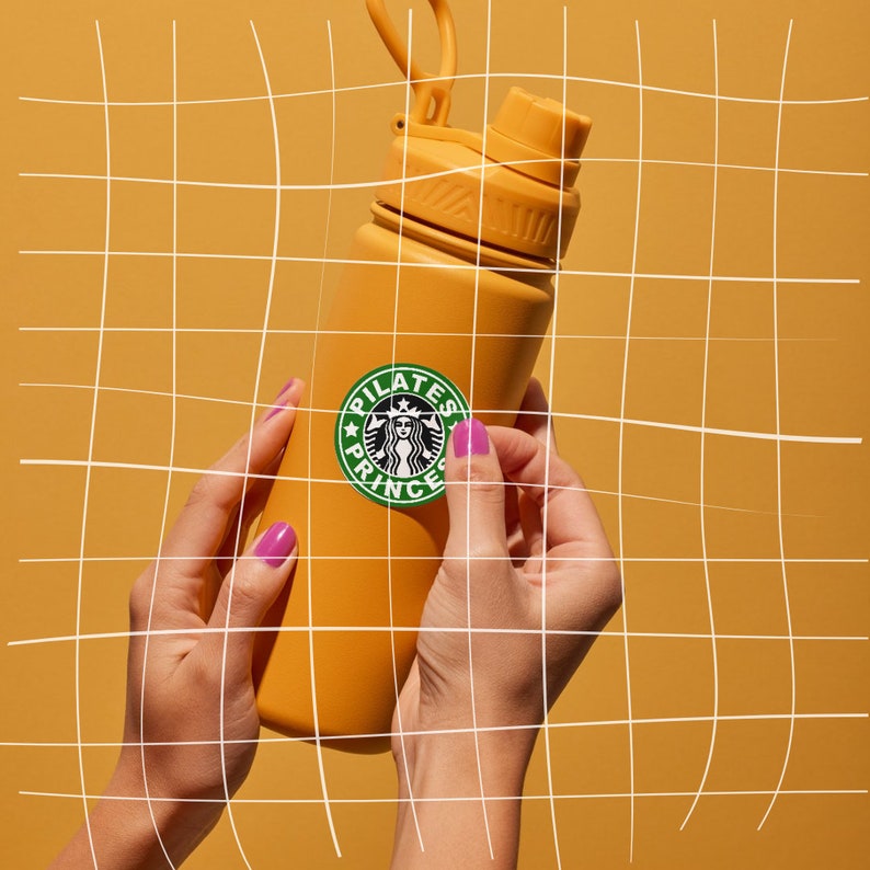 May include: A yellow water bottle with a white sticker that says "Pilates Princess" and a green Starbucks logo. The bottle is being held by a person's hands.