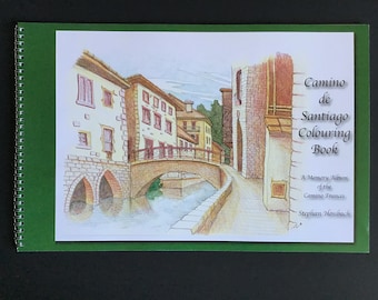 May include: A green cover with a spiral binding features a hand-drawn illustration of a bridge over a canal in a European village. The text on the cover reads "Camino de Santiago Colouring Book, A Memory Album of the Camino Frances, Stephan Hossbach".
