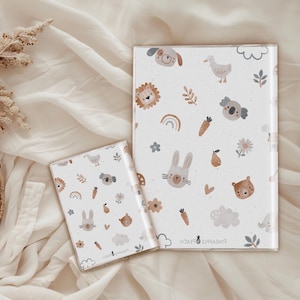 May include: Two white notebooks with a colorful pattern of animals, flowers, and rainbows. The larger notebook has the text "Pineapple & Peach" on the bottom.