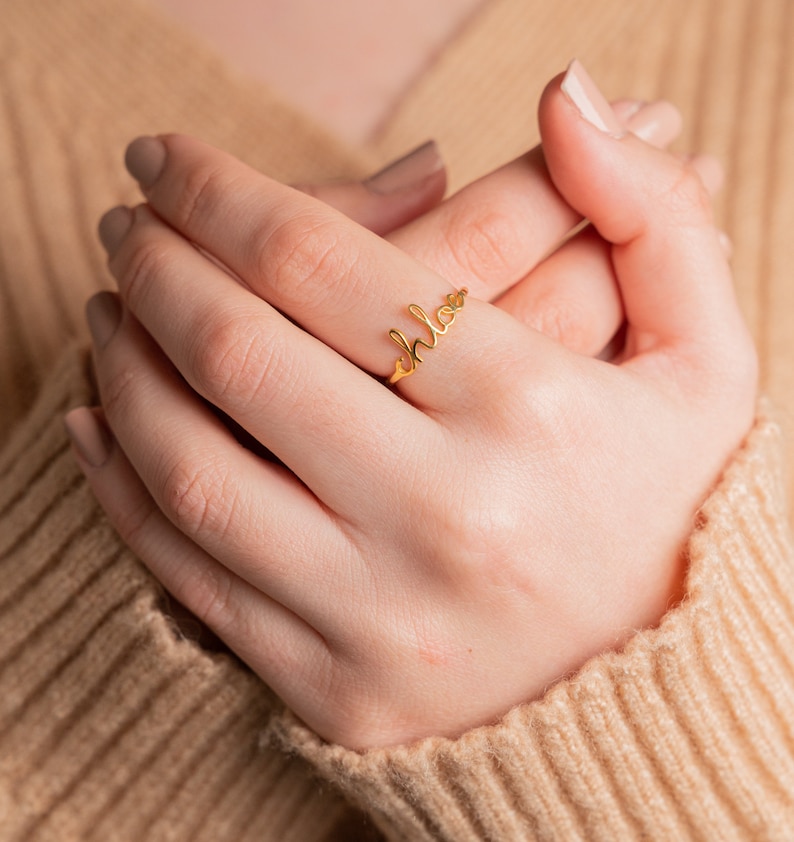 May include: A gold ring with the word "chloe" written in cursive script.